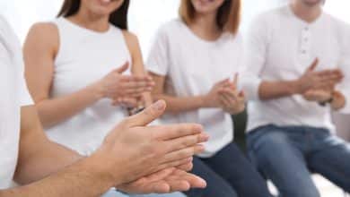 Grupo de j&oacute;venes aprendiendo lenguaje de se&ntilde;as con el maestro en el interior / Lenguaje de signos