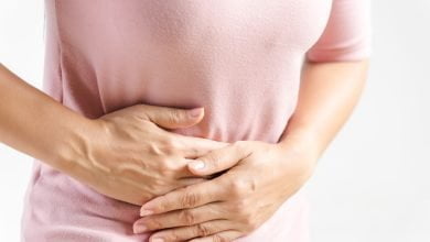 Joven mujer hermosa con doloroso est&oacute;mago en fondo blanco / estre&ntilde;imiento / guayaba / ir al ba&ntilde;o