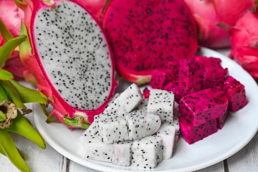 trozo de fruta de drag&oacute;n en plato blanco con fondo pitahaya / frutas ex&oacute;ticas