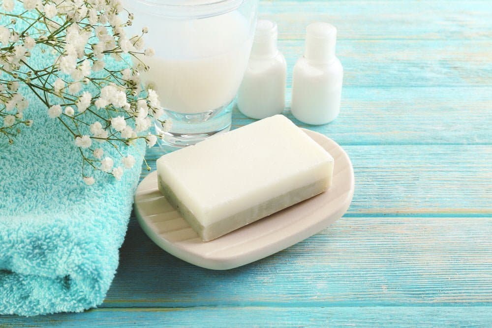 Jab&oacute;n sobre un plato con fondo de madera / compartir el jab&oacute;n